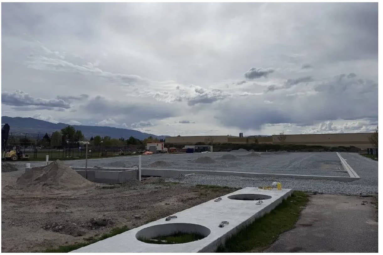 The Mission Recreation Park site under construction: gravel pads, concrete footings and the mountains beyond.